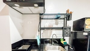 Une cuisine de taille réduite, équipée d’une cuisinière intégrée, d’un évier et d’un four à micro-ondes.