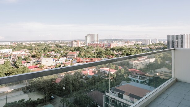 A high-rise building with a view of a cityscape, including various buildings and greenery. - Spacious & Cozy Urban Oasis (Iloilo)