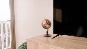 Un mueble de televisión de madera con un globo terráqueo y un televisor negro.