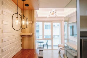 A modern kitchen with a wooden countertop, a built-in oven, and a large window. - A Warm & Cozy City Studio (Iloilo)