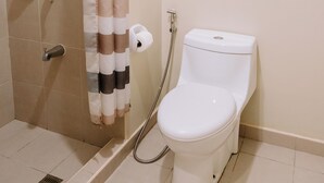 A bathroom with a shower, toilet, and a towel rack.