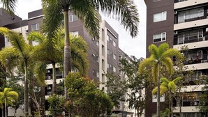 A swimming pool surrounded by lush greenery and modern apartment buildings. - Affordable & Luxe Retreat (Iloilo)