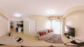 A living room with a sofa, TV, and a dining area with chairs and a table. - Relaxing Sanctuary in Iloilo (Iloilo)
