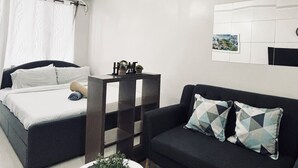 Un dormitorio moderno y minimalista con cama, sofá y una mesita de centro.