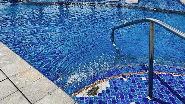 Una piscina con sillas de descanso y vistas al cielo.