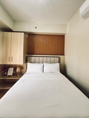 Ein modernes Schlafzimmer mit großem Bett, Holz-Kopfteil und eingebautem Kleiderschrank.