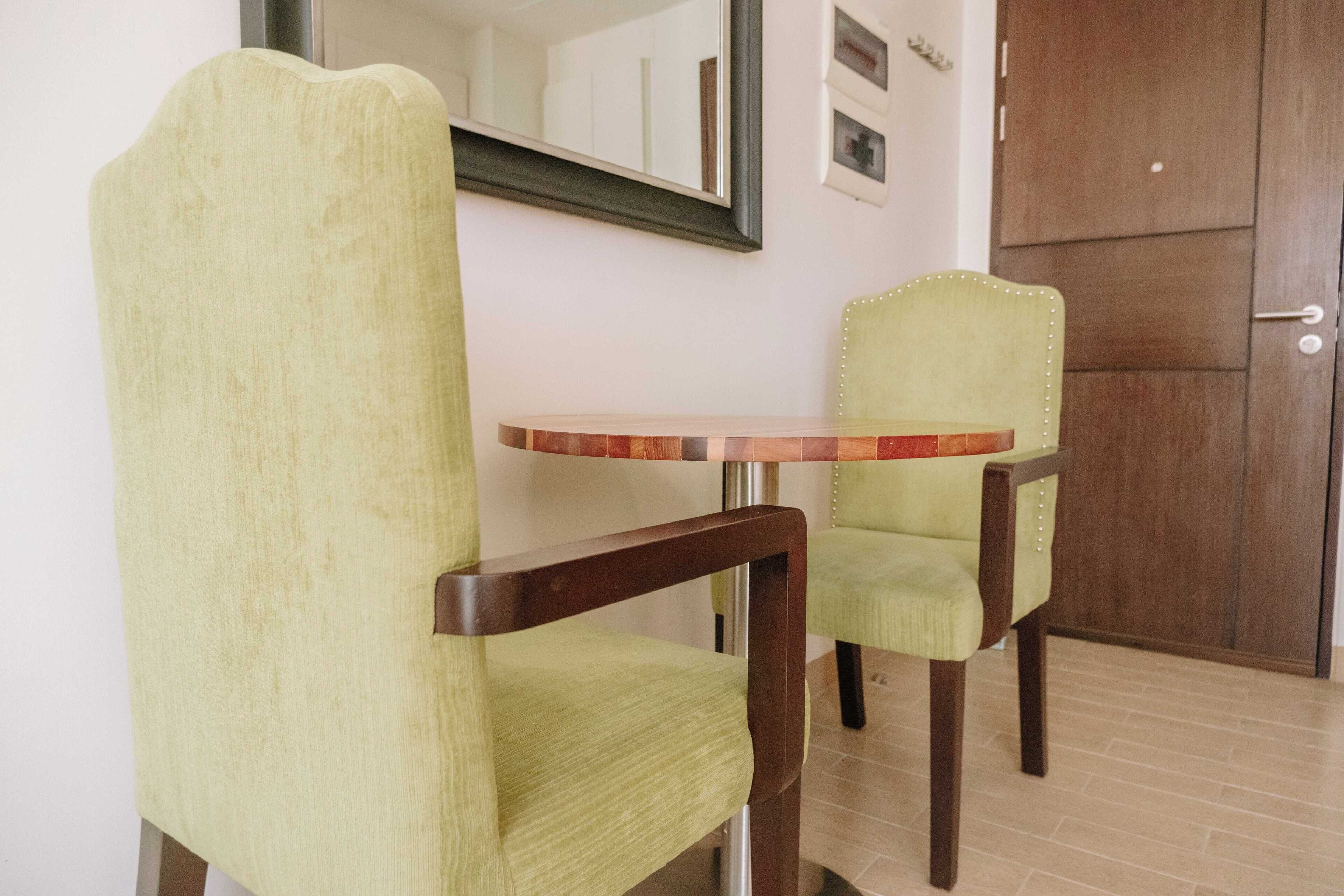 A room with a wooden chair and a small round table.