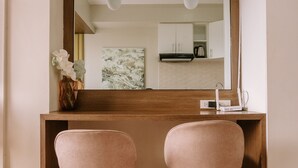 A modern bathroom with two pink stools, a wooden vanity, and a mirror above. - Chic & Stylish Urban Hideout (Iloilo)