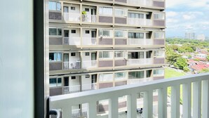 A multi-story building with balconies, a clear sky, and a view of the surrounding area. - Tropical Bliss in the Metro (Iloilo)
