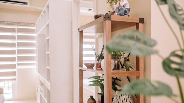 A wooden shelf with various decorative items and plants. - Playful & Charming City Loft (Iloilo)