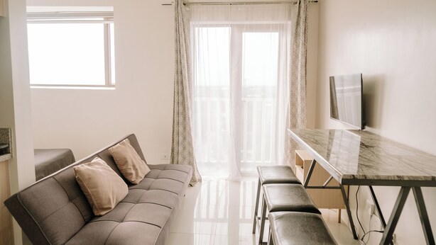 A modern living room with a sofa, a coffee table, and a TV. - Tranquility in the City (Iloilo)