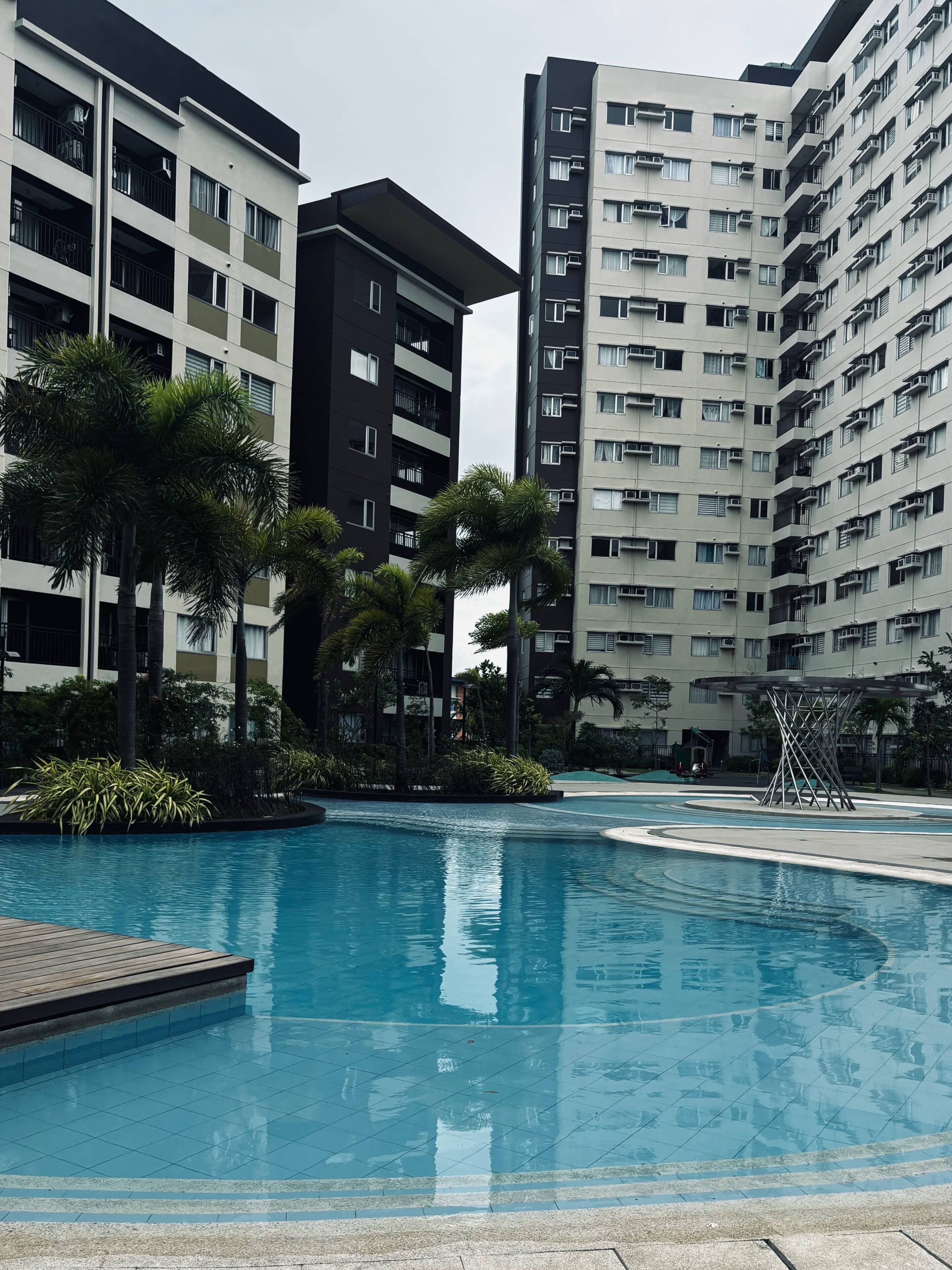 A modern residential building complex with a swimming pool.