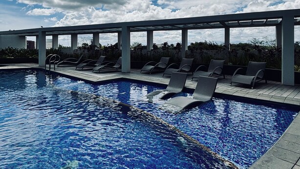 Ein Schwimmbad mit Liegestühlen und einer Pergola.