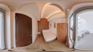 Une chambre moderne avec un plafond incurvé, un lit, une armoire et une vue sur le balcon.