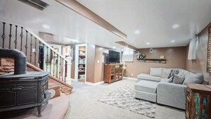 Un salón amplio con chimenea, un sofá y un televisor.