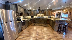 Una cocina moderna con electrodomésticos de acero inoxidable, armarios de madera y una pared decorativa de piedra.
