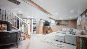 A spacious living room with a fireplace, a sofa, and a television.