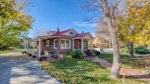 A two-story house with a brick facade, a red roof, and a front porch.