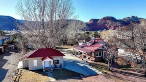 A residential area with houses, a driveway, and a mountain backdrop. - Serene downtown Kanab hub for Zion, Bryce, Lake Powell, & Grand Canyon with yard (Kanab)