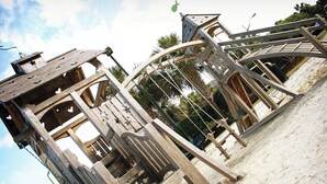 Una estructura de madera con varios niveles y espacios abiertos, posiblemente un pabellón o parte de un conjunto mayor.