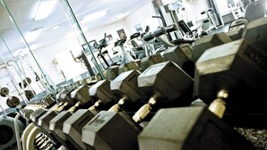 Un gimnasio con filas de mancuernas y equipamiento de ejercicio.