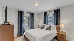 A neatly arranged bedroom with a bed, bedside tables, and a desk. - Cute 2-bedroom bungalow in downtown Raleigh (Raleigh)