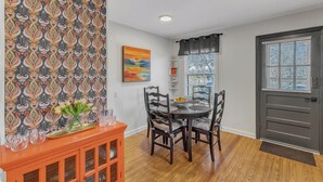 A dining area with a round table, chairs, and a decorative cabinet. - Cute 2-bedroom bungalow in downtown Raleigh (Raleigh)