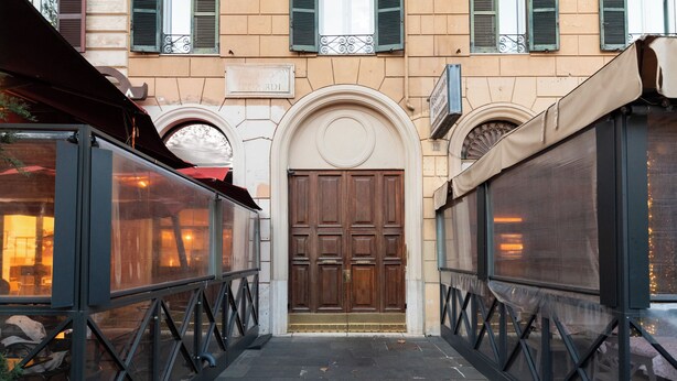 Une ruelle étroite avec une porte centrale et deux structures vitrées de chaque côté.