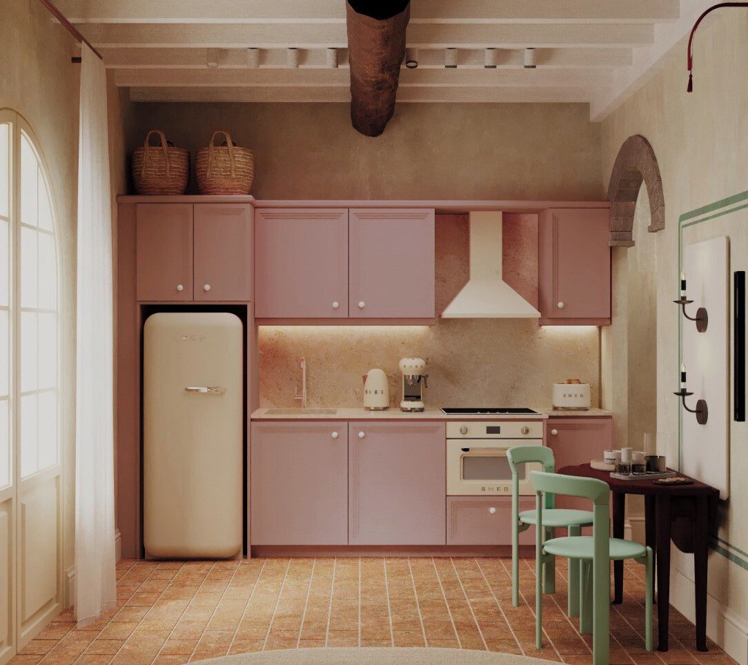 Eine Küche mit rosa Schränken, einem Kühlschrank, einem Herd und einer Spüle. Es gibt zwei Stühle und einen Tisch.