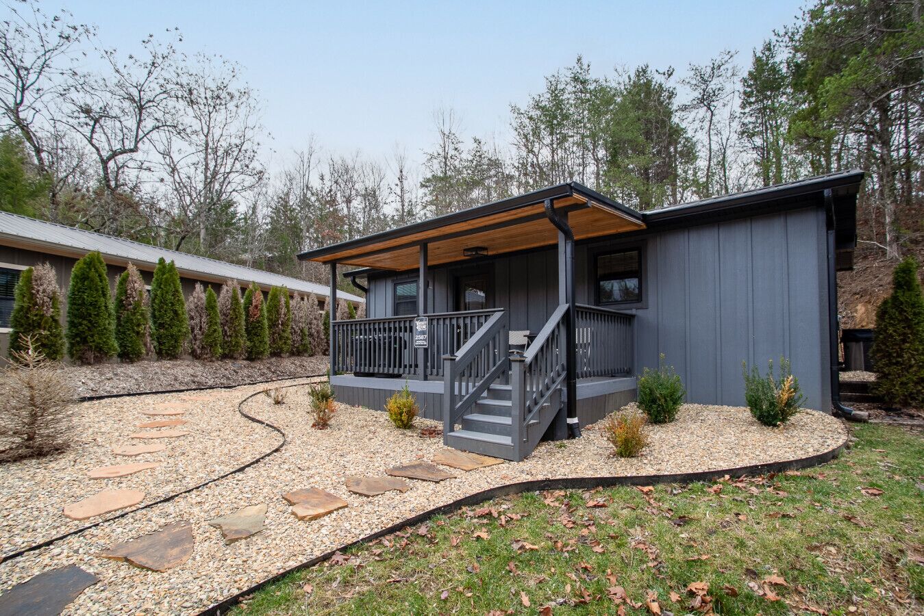 A modern two-story house with a covered porch and a stone pathway leading to the entrance.