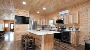 A modern kitchen with wooden paneling, stainless steel appliances, and a large island.