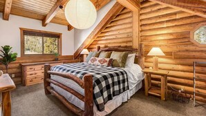 A log cabin bedroom with a wooden bed, a window, a lamp, and a plant. - Private Luxurious Cabin w spa Near Breckenridge (Breckenridge)