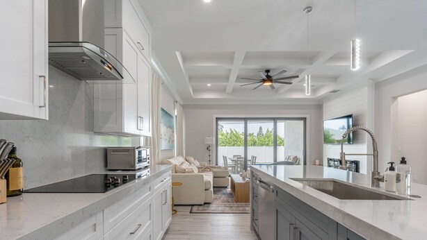 A modern kitchen with a large island, built-in appliances, and a view to the outdoors. - Sparkling new Vanderbilt Beach Luxury Escape (Naples)