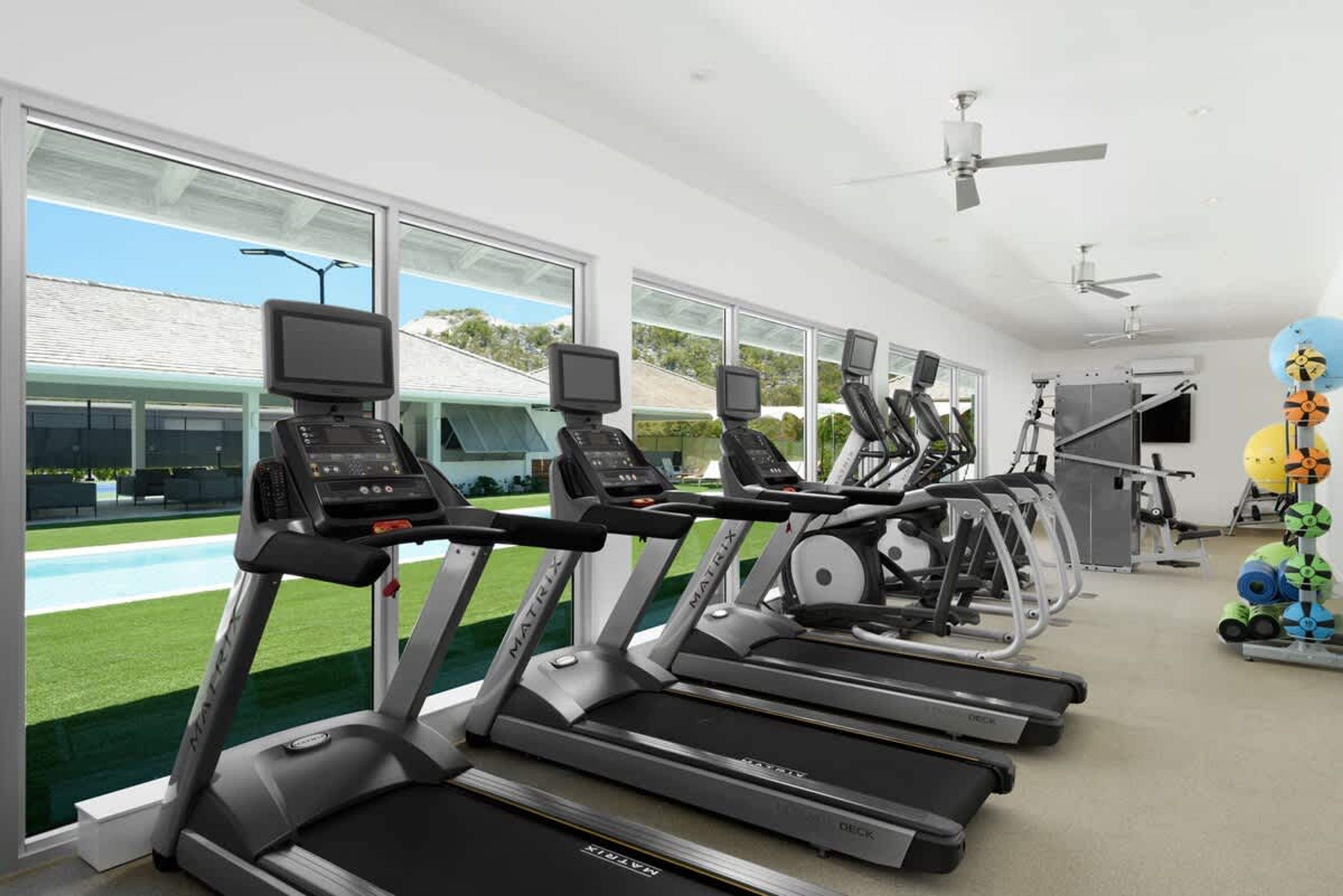 A gym with treadmills, exercise bikes, and a rowing machine.