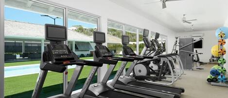 A gym with treadmills, exercise bikes, and a rowing machine.