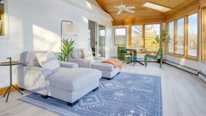 A modern living room with a wooden ceiling, large windows, and a blue patterned rug. - Billingswood by Boutiq (Athens)