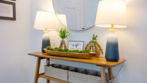 A wooden console table with two lamps, a mirror, a sign reading "wifi," and a decorative plant arrangement. - Fun Family-friendly Largo Home Heated Pool (Largo)