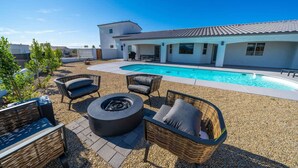 A modern outdoor pool area with a hot tub, wicker furniture, and a covered patio. - Lavish Lake Havasu Villa Pool Fire Pit an Views (Lake Havasu City)