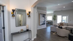 A spacious living area with a large mirror, console table, and a modern sofa. - Lavish Lake Havasu Villa Pool Fire Pit an Views (Lake Havasu City)