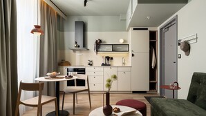 Un espace de vie compact comprenant un coin repas, une kitchenette et un coin salon.