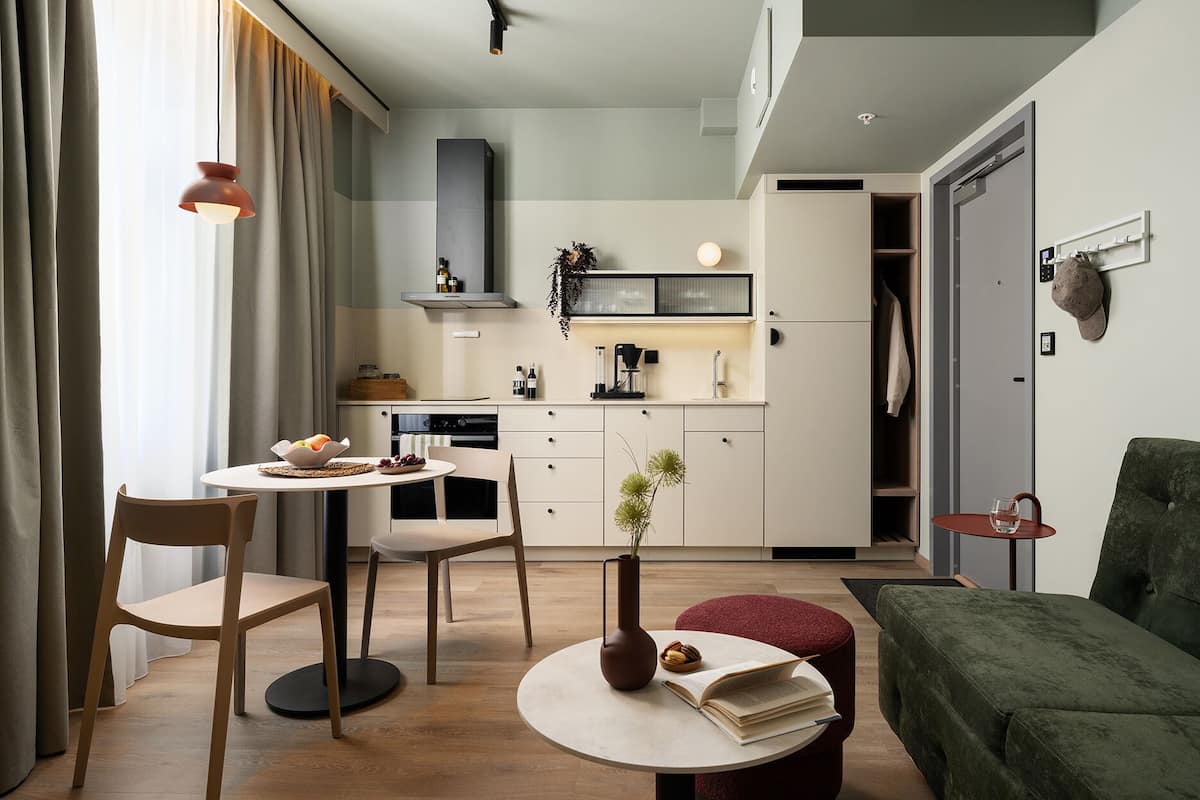 Ett kompakt bostadsutrymme med en matplats, ett litet kök och en sittgrupp.
