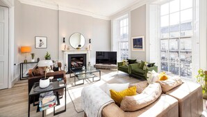 A spacious living room with a fireplace, a television, and comfortable seating. - Stunning 4 bedroom Townhouse in central Edinburgh with garden & private parking (Edinburgh)