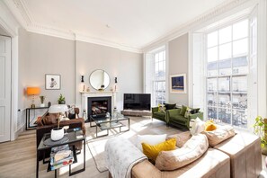 TV connectée, cheminée, livres, chaîne hi-fi