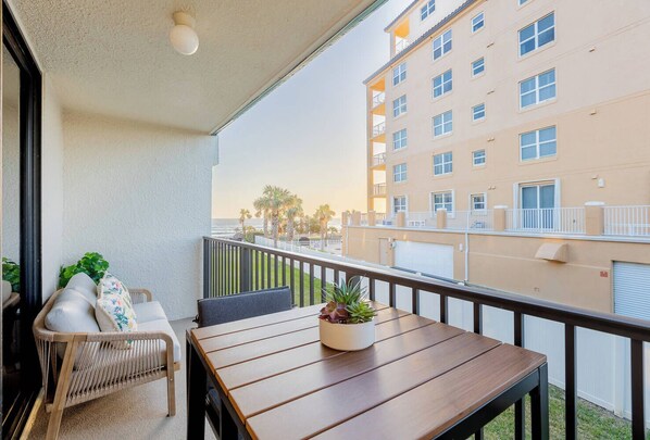 Enjoy a peaceful moment on this balcony with a table and two chairs, perfect for taking in the views of the surrounding cityscape.