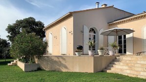 A house with a patio, a barbecue grill, and potted plants. - Les Lauriers Roses house with swimming pool - popular area Isle sur la Sorgue (L'Isle-sur-la-Sorgue)