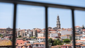 A cityscape with a prominent tower, dense urban buildings, and a clear sky. - GuestReady - Old City Design - Faces (Porto)