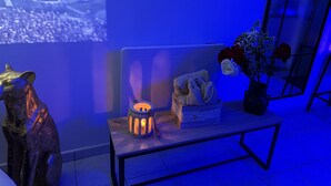 A modern room with a sofa, a small table with a lantern, and a decorative sculpture. - Suite Eden Spa, Appart’hôtel bien être , Patio (Avion)