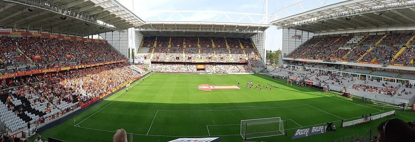 Een groot stadion met meerdere verdiepingen van zitplaatsen, een middenveld en een doelpunt.
