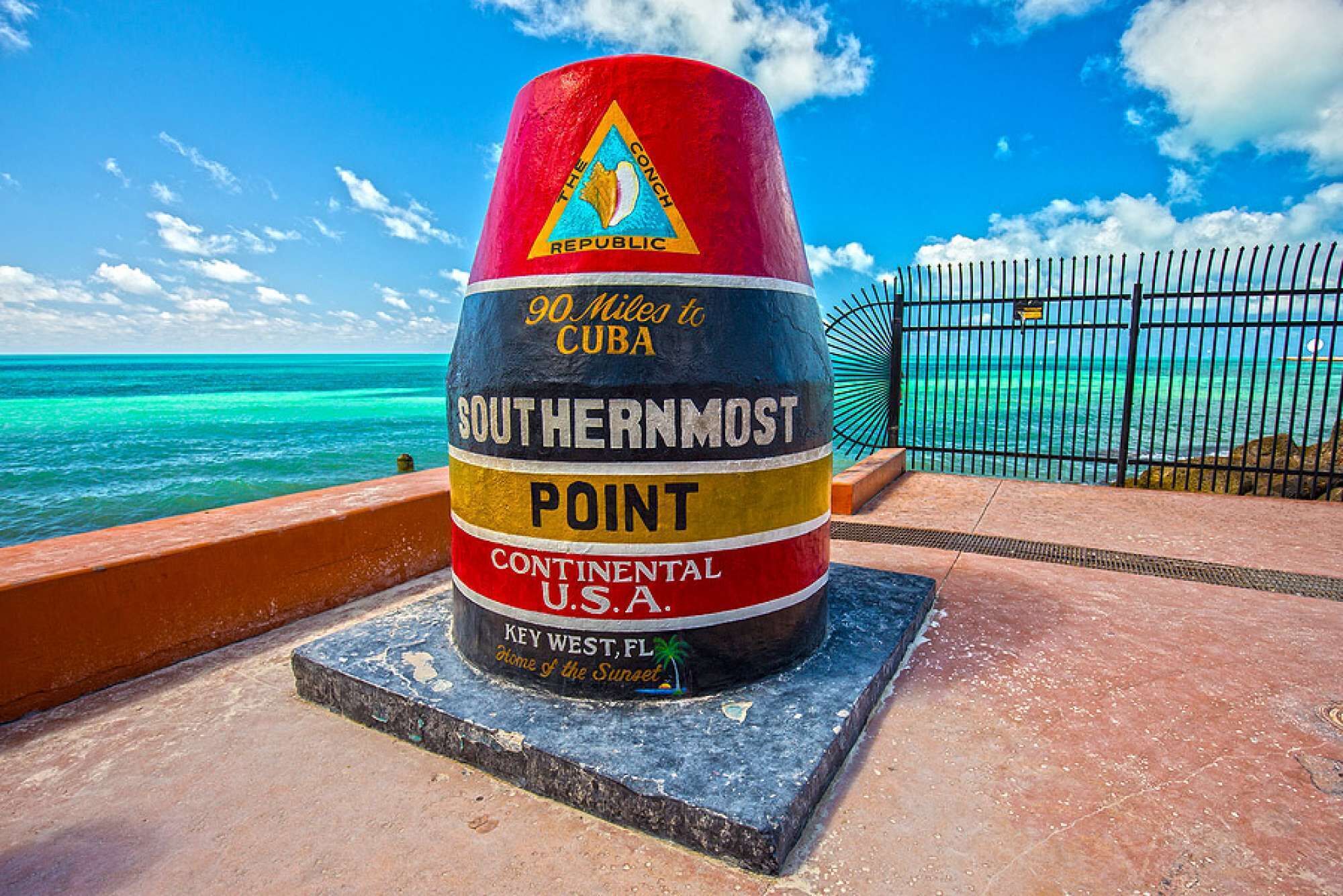 A colorful marker labeled '90 Miles to Cuba' at Key West, FL, indicating its location near the ocean.