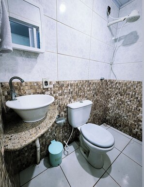 Een douche, handdoeken, zeep, toiletpapier